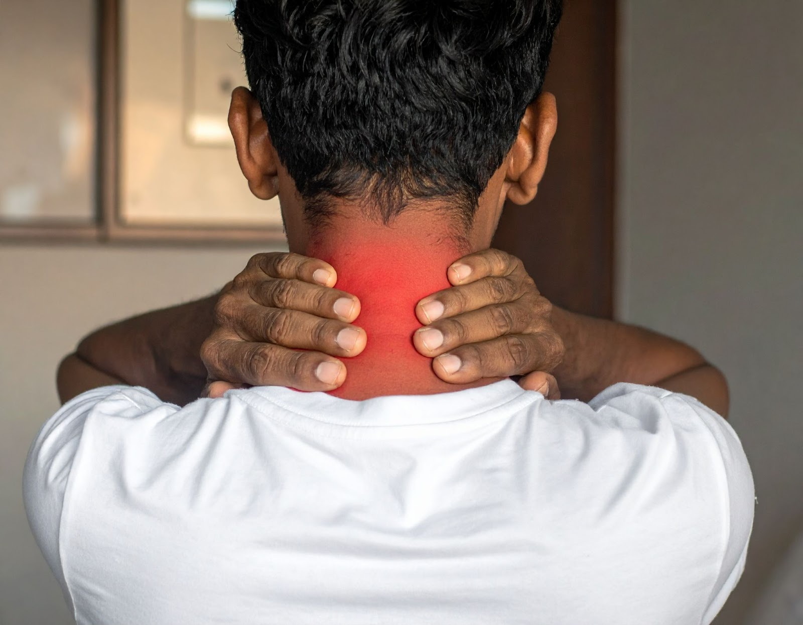 男子雙手按著後頸露出痛苦表情，象徵頸椎間盤突出早期疼痛警訊
