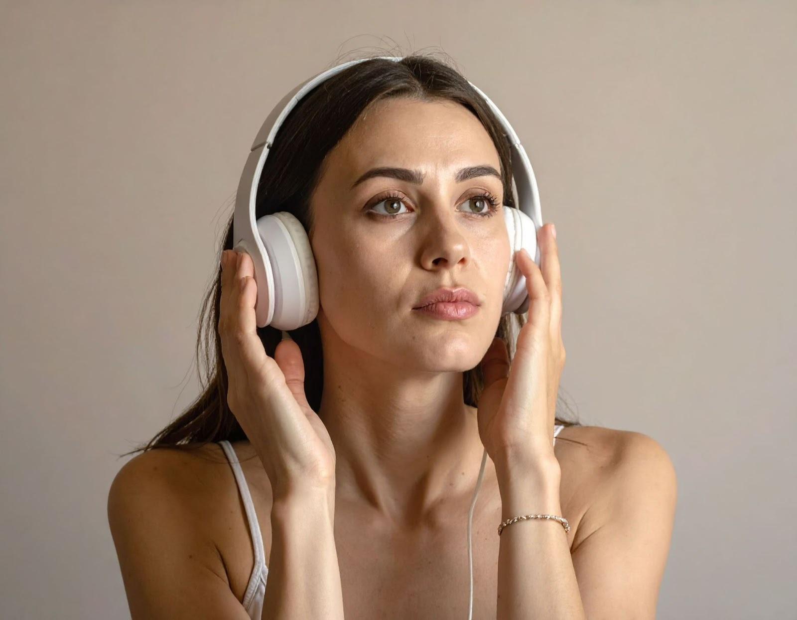 女子正在用耳機聽音樂，臉上表情不適