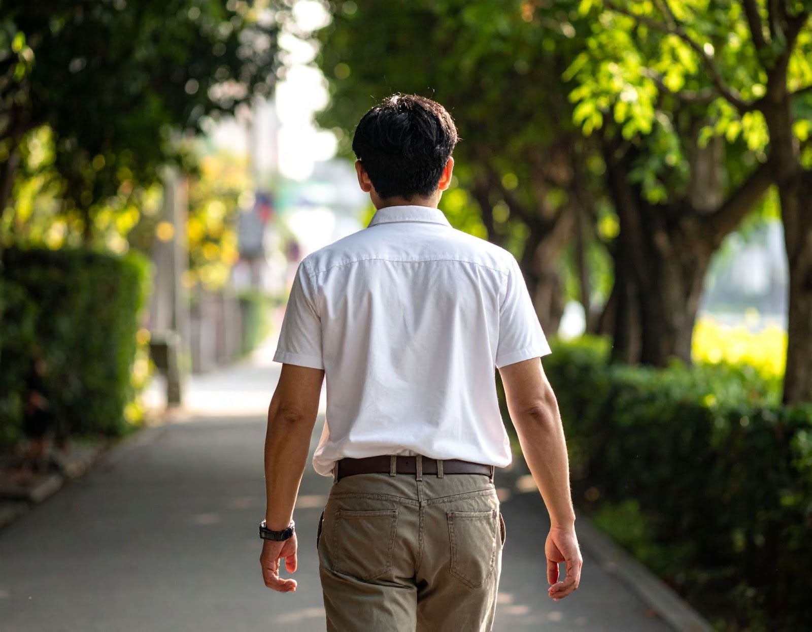 男子（亞洲人）扶著下背部緩慢行走