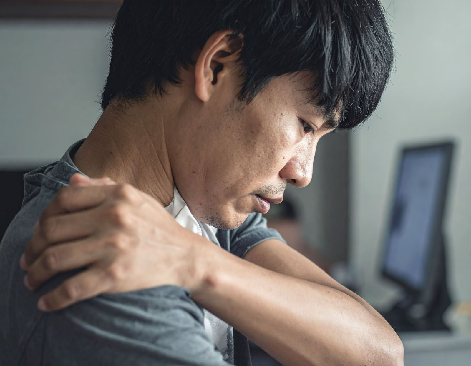 男子（亞洲人）低頭辦公肩頸僵硬