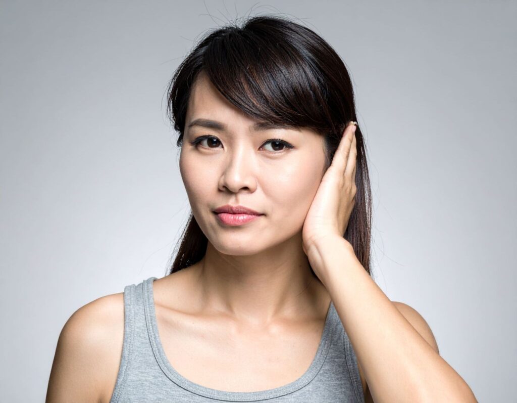 女性（亞洲人）一手摀耳感到不適